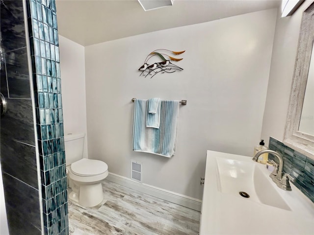 bathroom with hardwood / wood-style flooring, vanity, and toilet