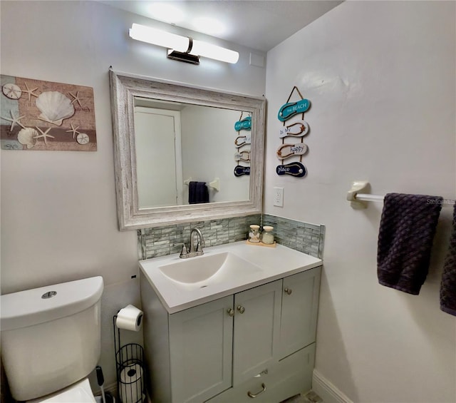 bathroom with vanity, toilet, and decorative backsplash