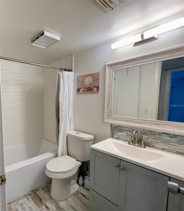 full bathroom featuring backsplash, hardwood / wood-style floors, vanity, toilet, and shower / bath combo with shower curtain