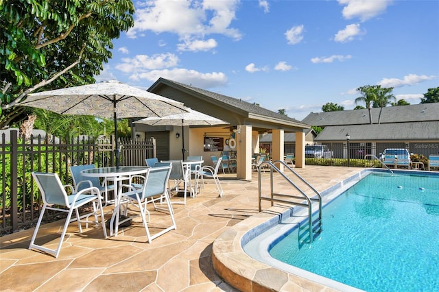 pool with a patio area and fence