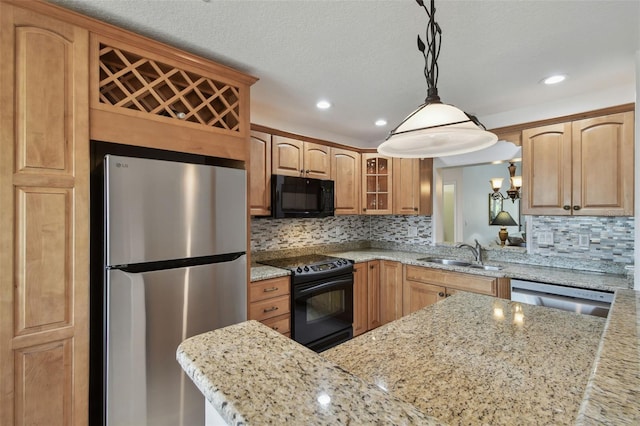 kitchen with a sink, glass insert cabinets, light stone countertops, and black appliances