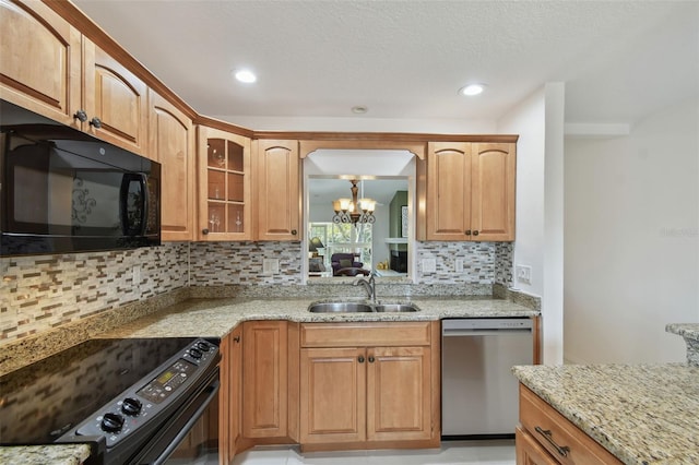 kitchen featuring black appliances, a sink, light stone counters, glass insert cabinets, and a chandelier