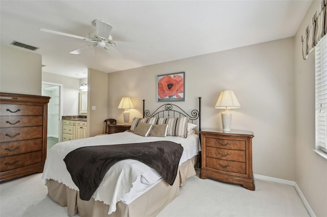 bedroom featuring visible vents, light carpet, ensuite bathroom, baseboards, and ceiling fan