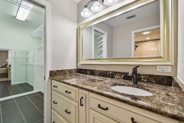 full bath featuring tile patterned floors, visible vents, a spacious closet, and vanity