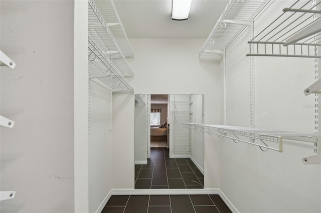 walk in closet with dark tile patterned flooring