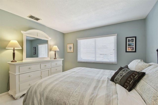 bedroom featuring visible vents and a textured ceiling