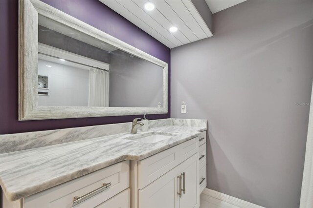 full bathroom with vanity, recessed lighting, and baseboards