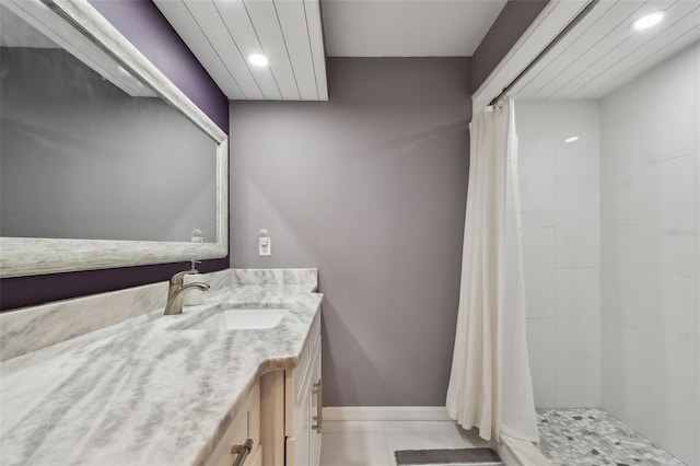 full bathroom with tile patterned floors, recessed lighting, baseboards, tiled shower, and vanity