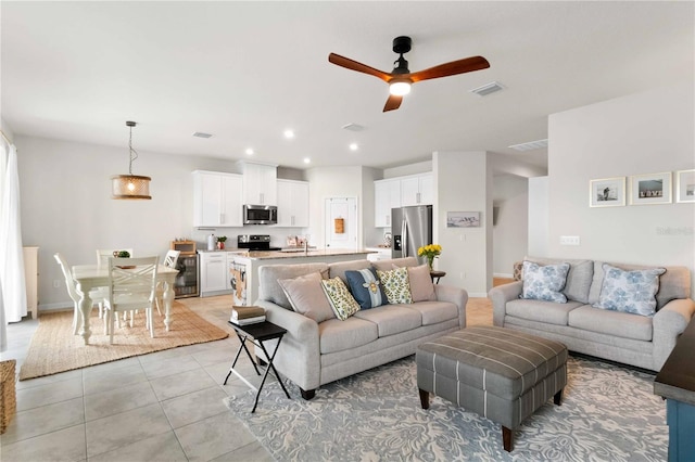 living room with wine cooler, light tile patterned floors, and ceiling fan