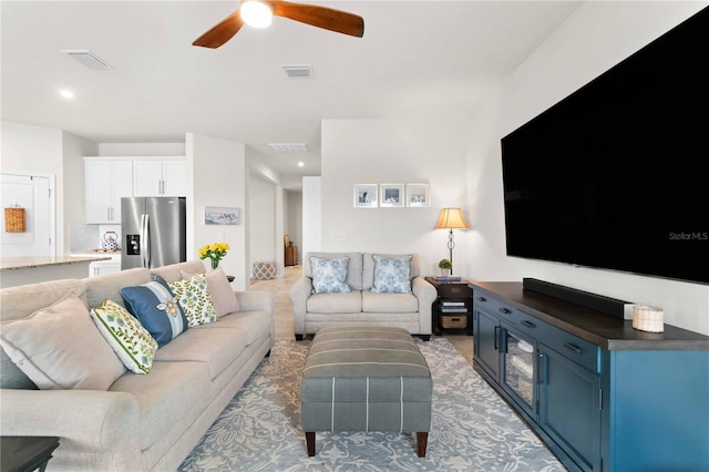 carpeted living room with ceiling fan