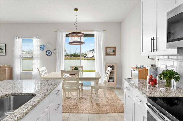 kitchen with white cabinetry, light stone countertops, and plenty of natural light