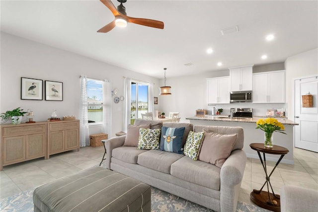 tiled living room featuring ceiling fan