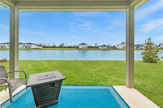 view of swimming pool featuring a yard and a water view