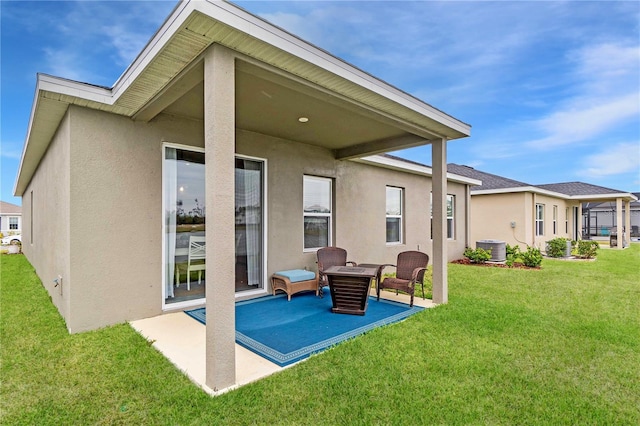 rear view of property featuring a lawn, a patio, and central air condition unit