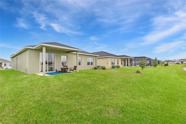 rear view of house with a patio area and a lawn