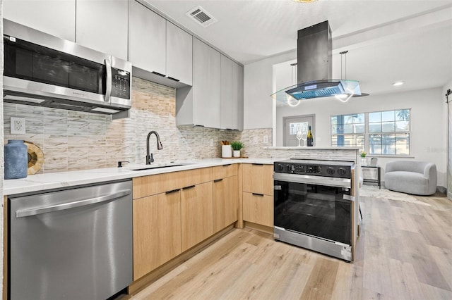 kitchen with light brown cabinetry, sink, tasteful backsplash, appliances with stainless steel finishes, and island exhaust hood