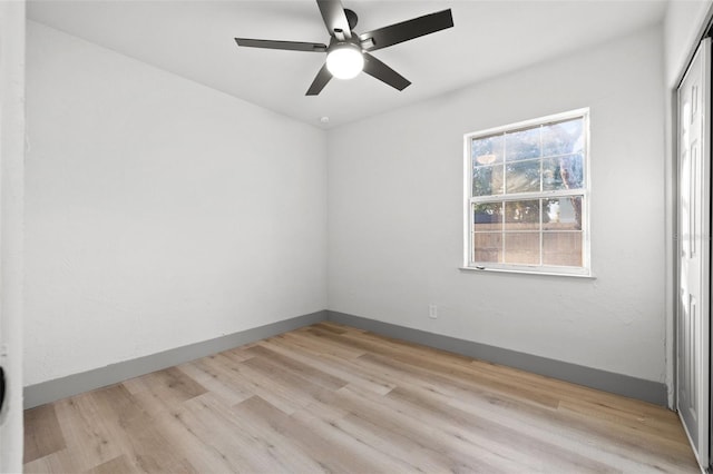 empty room with ceiling fan and light hardwood / wood-style floors