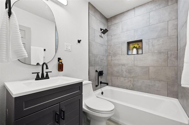 full bathroom featuring tiled shower / bath, vanity, and toilet