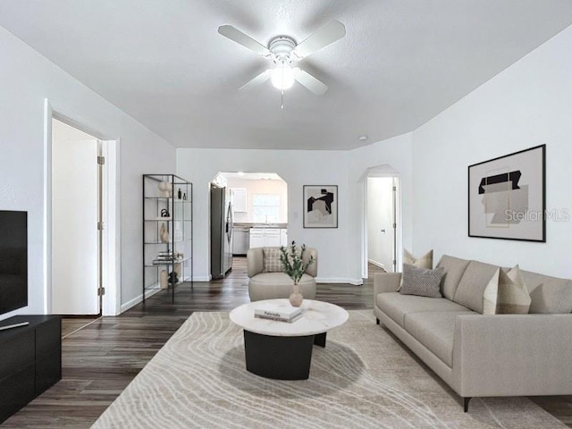 living room with ceiling fan and dark hardwood / wood-style floors