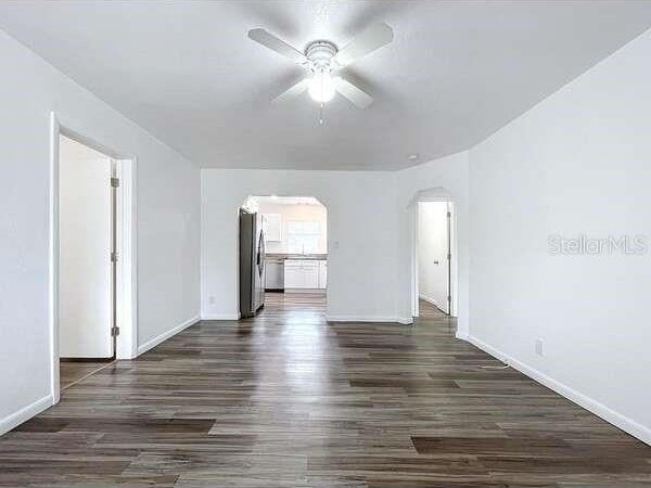 spare room featuring dark hardwood / wood-style flooring and ceiling fan