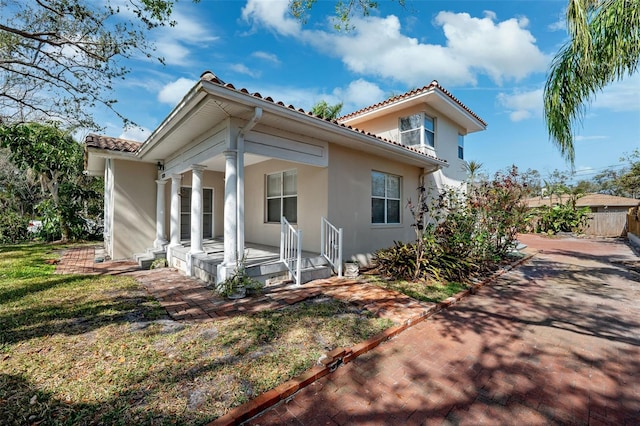 back of property featuring a porch and a lawn