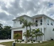 view of front of property featuring a balcony, a garage, and a front lawn