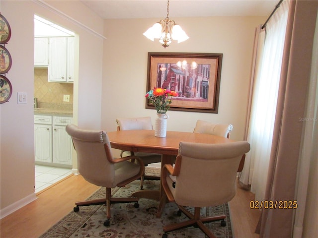 dining room featuring a notable chandelier and light wood-type flooring