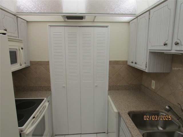 kitchen with backsplash, white appliances, sink, and white cabinets