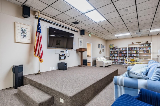 carpeted living room featuring a drop ceiling