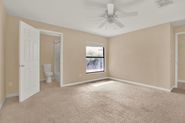 unfurnished bedroom featuring light carpet, ceiling fan, and ensuite bathroom