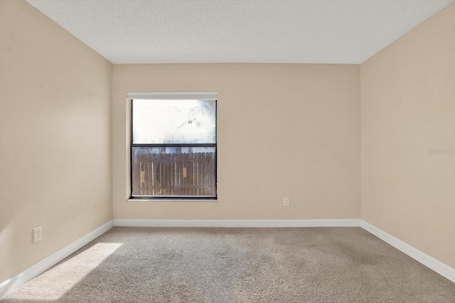 carpeted empty room featuring a textured ceiling