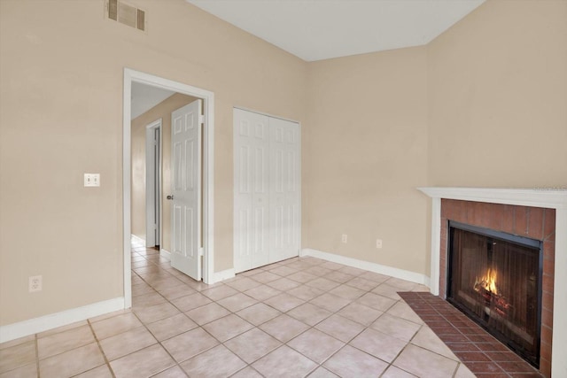 unfurnished living room featuring a tiled fireplace and light tile patterned floors