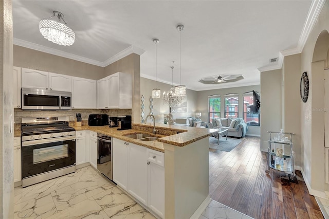 kitchen with sink, decorative light fixtures, kitchen peninsula, stainless steel appliances, and white cabinets