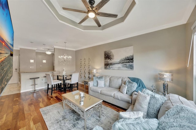 living room with hardwood / wood-style floors, ceiling fan with notable chandelier, and ornamental molding