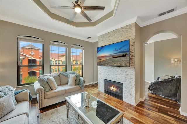 living room with ornamental molding, hardwood / wood-style floors, and a fireplace