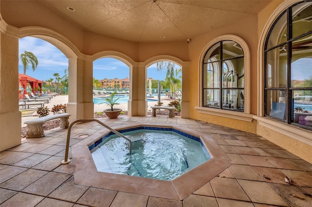 view of pool with a community hot tub and a patio area