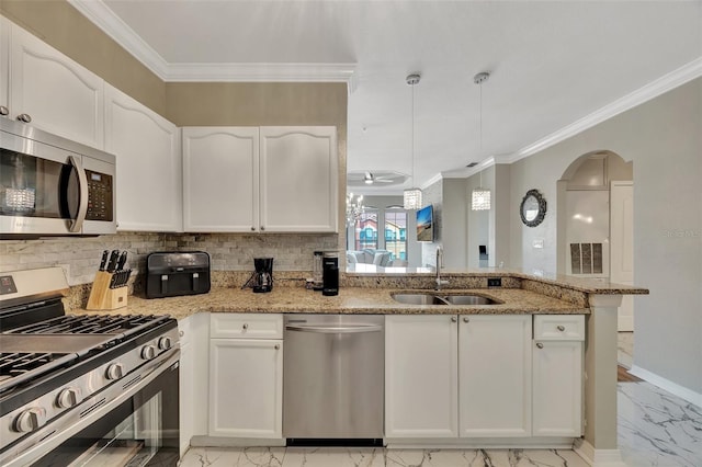 kitchen with white cabinetry, stainless steel appliances, light stone countertops, and sink