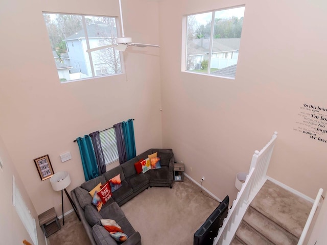 unfurnished living room with ceiling fan, a healthy amount of sunlight, and carpet