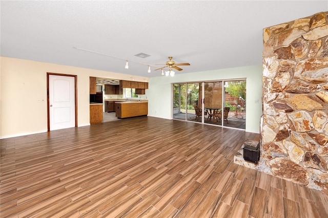 unfurnished living room with wood-type flooring, ceiling fan, and a textured ceiling