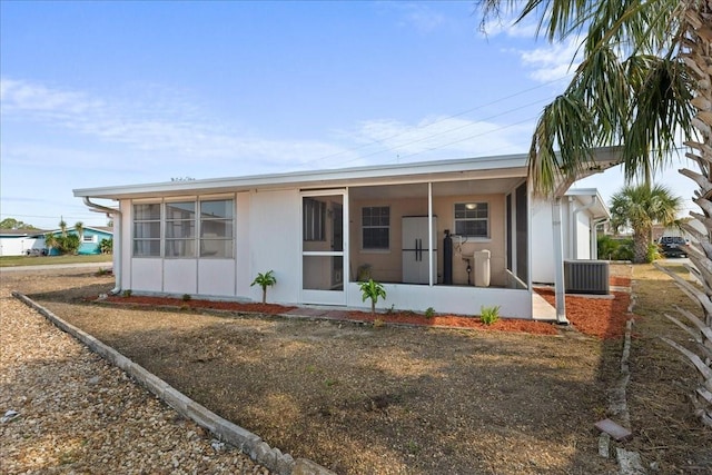 rear view of house with a sunroom and central air condition unit