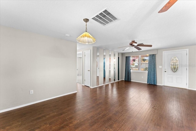 unfurnished living room with a textured ceiling, dark hardwood / wood-style floors, and ceiling fan