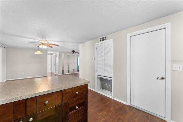 kitchen featuring ceiling fan, dark brown cabinets, dark hardwood / wood-style floors, and a textured ceiling