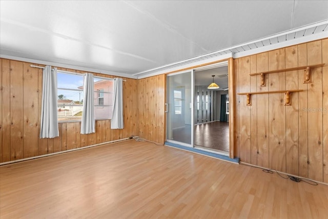 spare room with hardwood / wood-style floors and wood walls