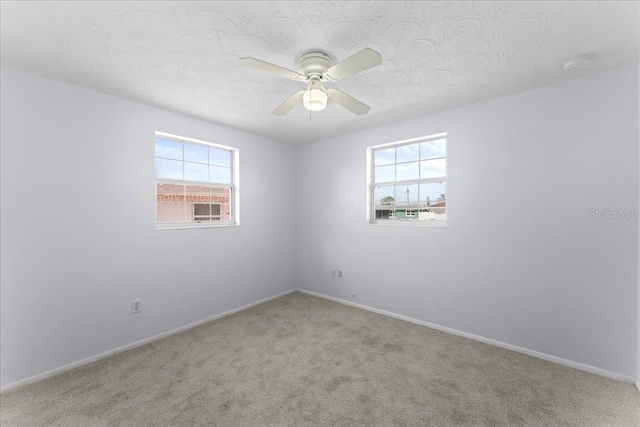 carpeted empty room featuring a textured ceiling and ceiling fan