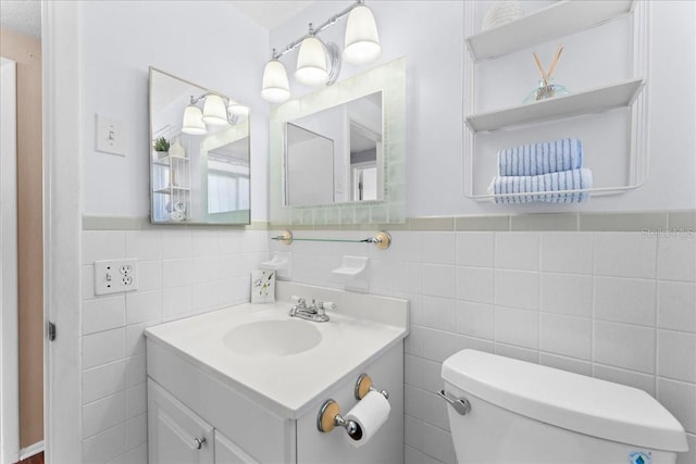 bathroom with vanity, tile walls, and toilet