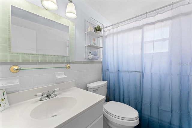 bathroom with vanity, tile walls, curtained shower, and toilet