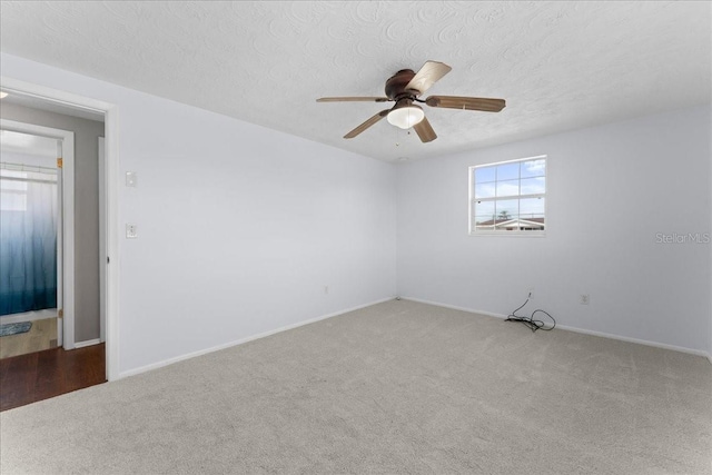 empty room with ceiling fan, carpet floors, and a textured ceiling