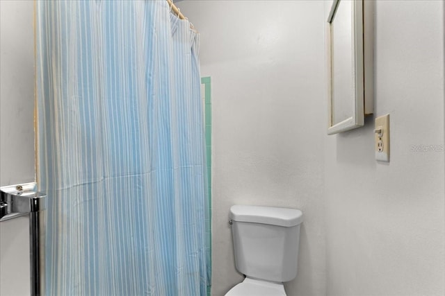 bathroom featuring a shower with shower curtain and toilet