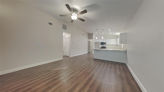 unfurnished living room with ceiling fan, dark hardwood / wood-style flooring, and sink