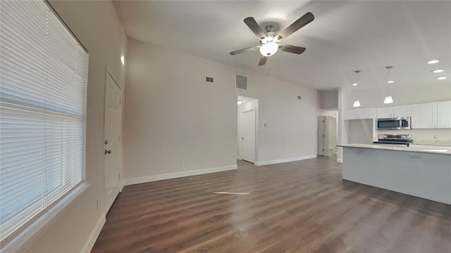 unfurnished living room with dark wood-type flooring, ceiling fan, and vaulted ceiling